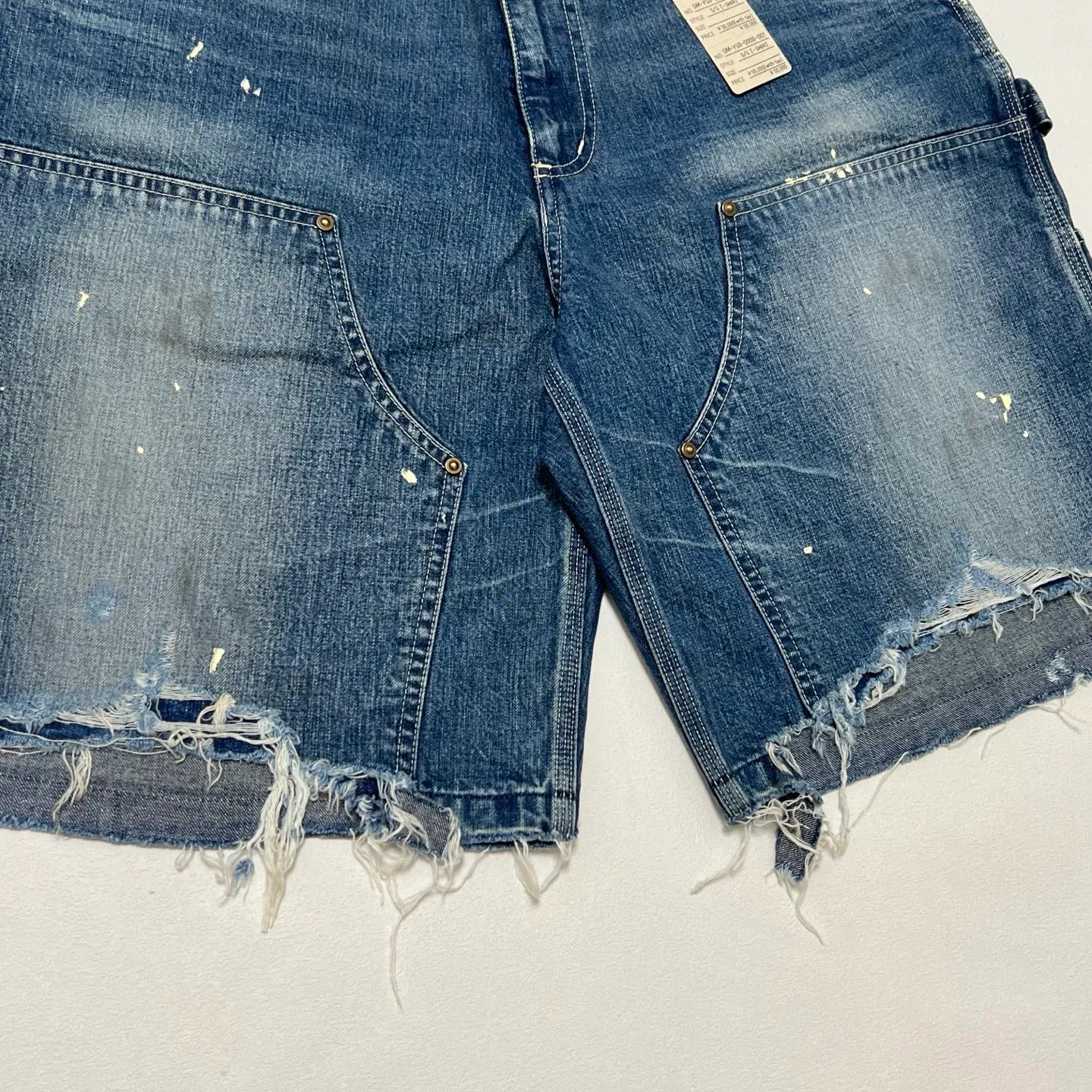 SAINT Mxxxxxx DOUBLE KNEE SHORTS/BLU Knee patches splashed with ink and water-splashed denim shorts. Denim blue S-XL. Custom-woven and dyed denim fabric with clear texture. Heavy-wash water-fading treatment to create local mottled fading/hole effects. Artificial distressing to simulate natural wearing marks. VINTAGE sense. Original consistent damage treatment. Hand-splashed ink and paint. Original consistent wash mark/pocket mark. Double knee patch. Rivet reinforcement. Improve functionality while enhancing design